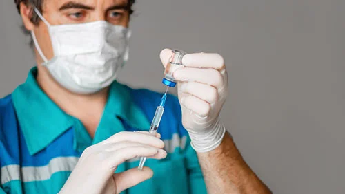 Доктор набирает шприц